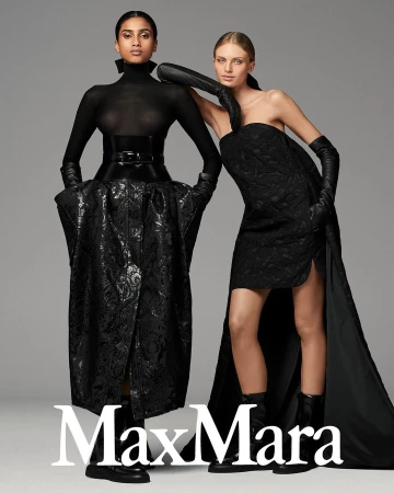 Two female models in black attire posing against a grey seamless studio background with the Max Mara logo visible.
