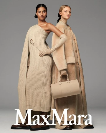 Two women model neutral-toned Max Mara knitwear, a wool coat, and leather accessories in a studio shot with a muted gray background.