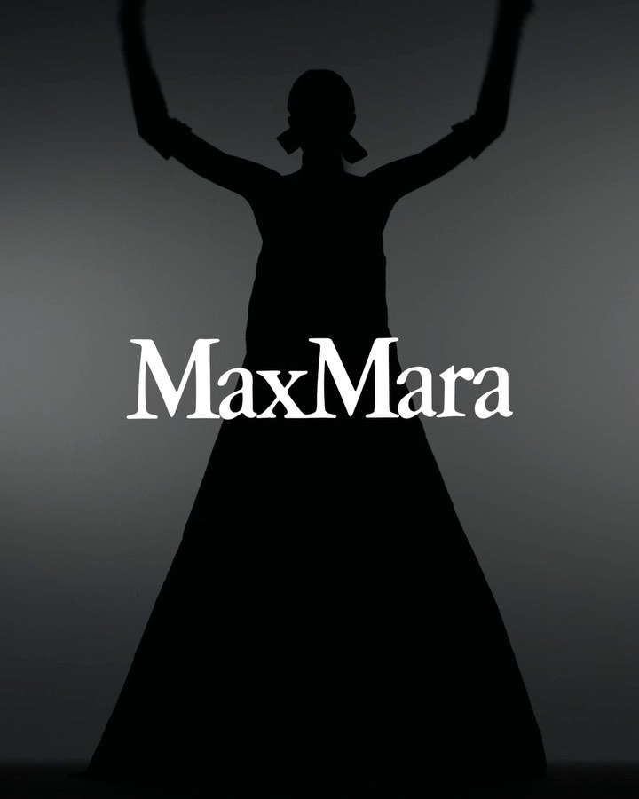 Silhouette of a woman in a long dress with her arms raised against a gradient gray background, featuring the Max Mara logo.