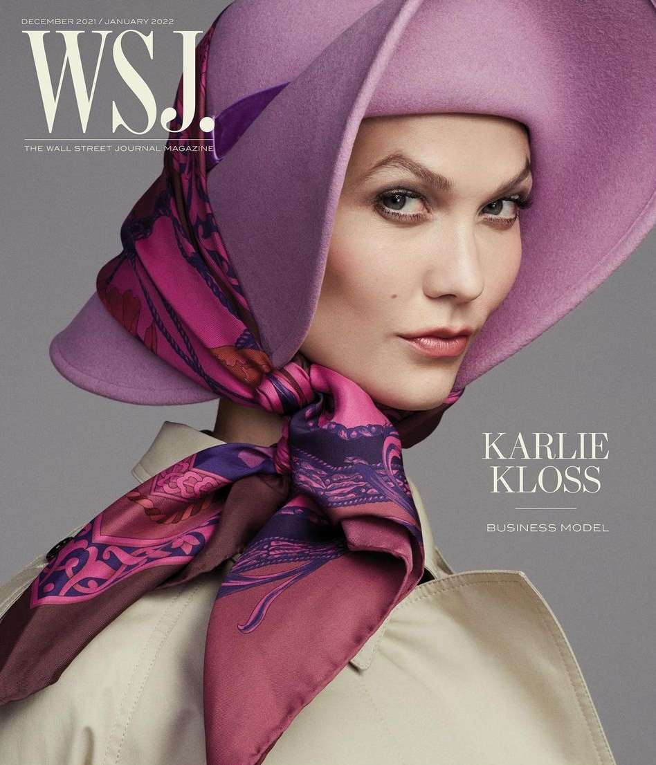Magazine cover featuring Karlie Kloss in lilac hat and patterned scarf, wearing a trench coat, posing in a close-up indoor studio shot.