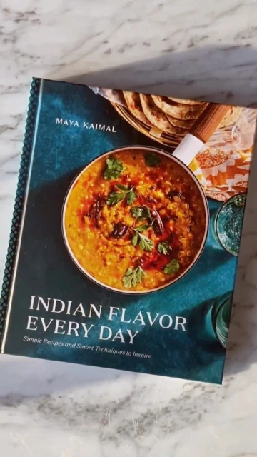 Book cover featuring Indian cuisine, dal and flatbreads, titled 'Indian Flavor Every Day' by Maya Kaimal, on a marble surface.