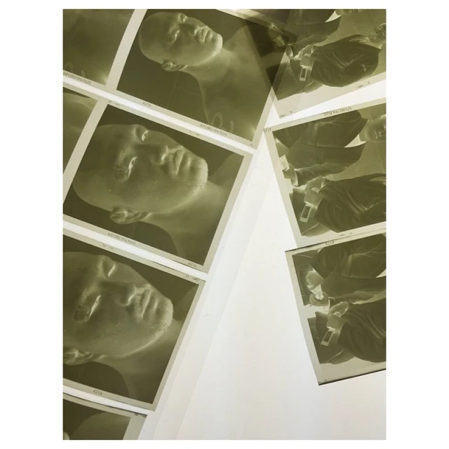 Collection of photographic prints featuring portrait of a human face, arranged against a white surface, exhibiting a vintage aesthetic.
