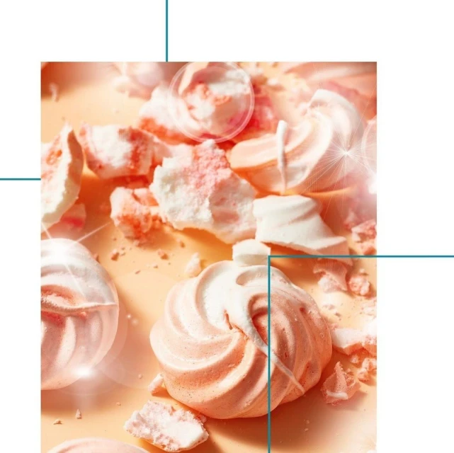 Close-up of pink and white meringues on a light background, some whole and some broken into pieces, creating a visually appealing dessert shot.