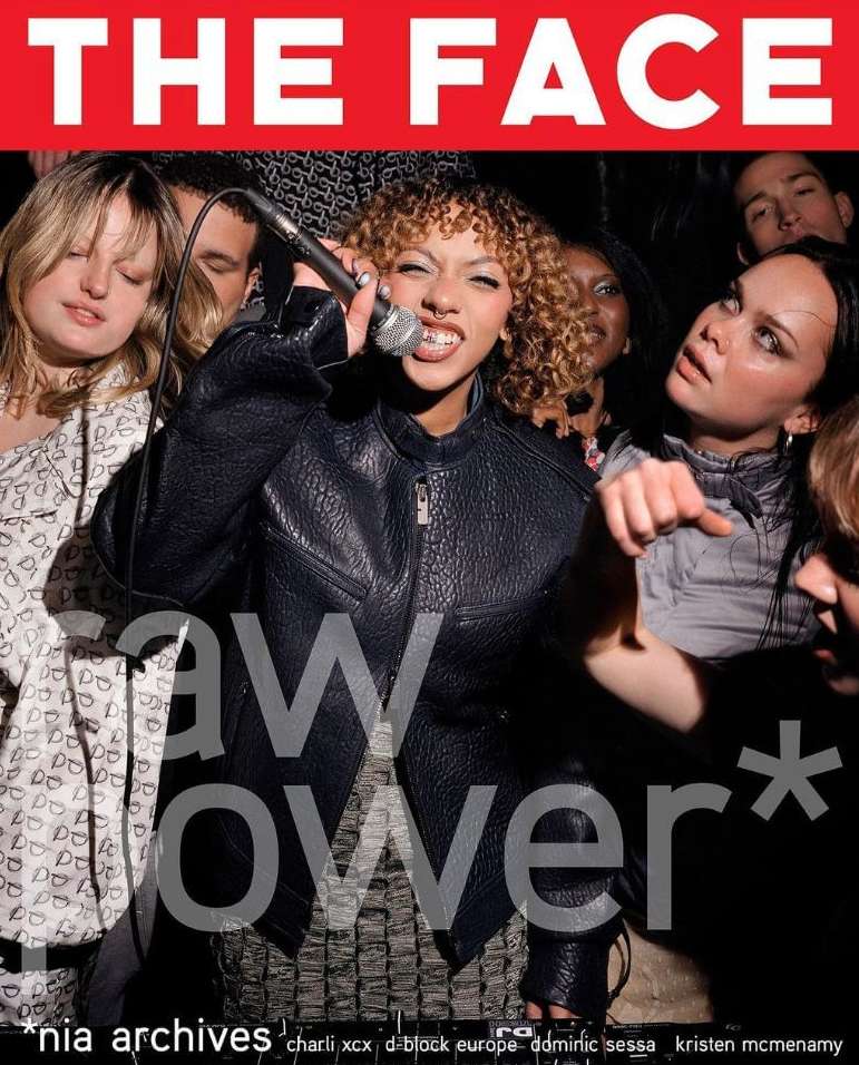 Magazine cover featuring a singer with a microphone, surrounded by several other individuals in a dimly lit setting with red branding.