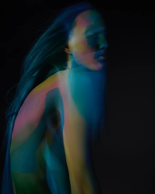 Abstract portrait of an adult with flowing hair, rendered in blended turquoise, blue, yellow, and pink hues against a dark background.