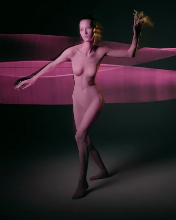 A nude woman stands in a studio with dynamic pink light painting for a visually striking effect, captured in a studio setting.