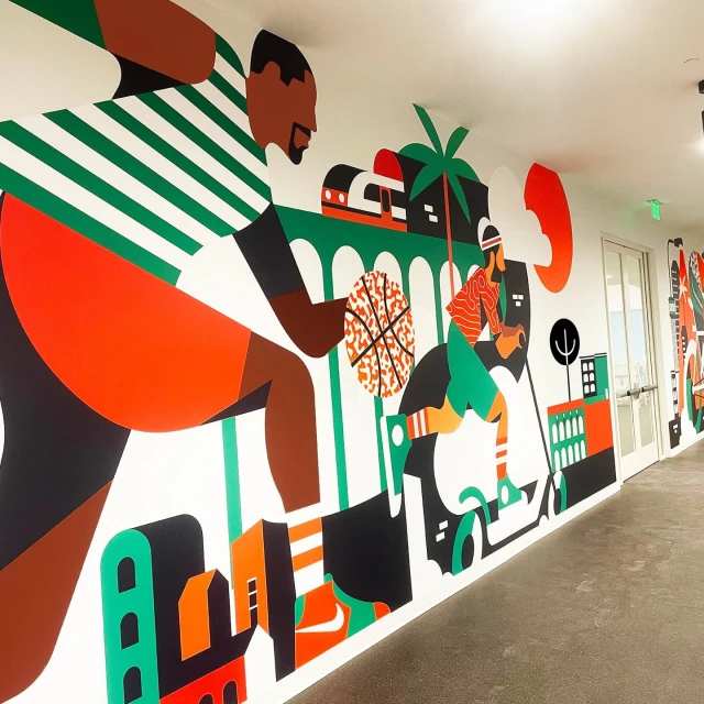 A colourful mural on a white wall depicts figures playing sports, including basketball, against an urban and tropical landscape backdrop.