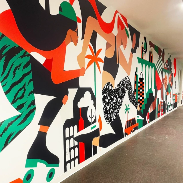 Mural art displays two stylized figures on roller skates, featuring bold colors, abstract buildings, and tropical palm tree motifs.