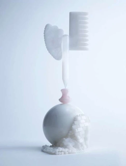 Stylized shot of white Gua Sha tool, comb, spherical object, and decorative beads against a soft, light background for beauty aesthetic.