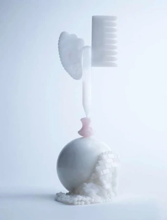 Stylized shot of white Gua Sha tool, comb, spherical object, and decorative beads against a soft, light background for beauty aesthetic.