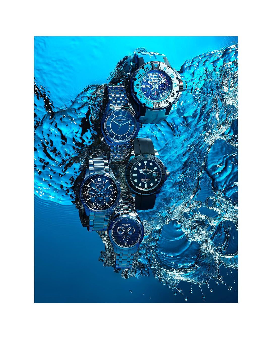 Underwater shot of five assorted wristwatches, including stainless steel bands and black rubber straps, in a vibrant blue water environment.