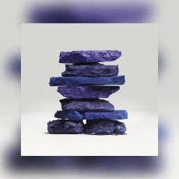 Balanced stack of rough blue pigmented stones against a minimalist white background by Fabrice Bouquet