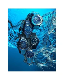 Five luxury blue luxury wristwatches submerged in clear blue water with dramatic splashing effects by Fabrice Bouquet