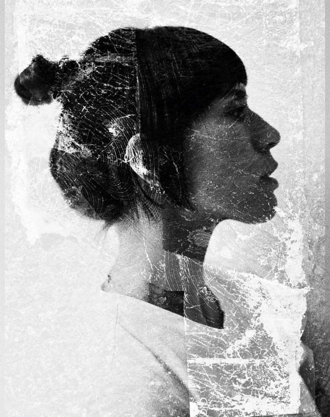 Monochrome portrait of a woman in profile with a textured overlay, artistic and pensive, black and white, textured background.