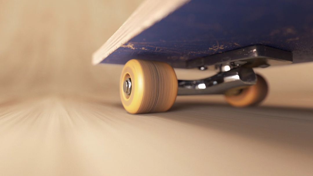 Close-up of a skateboard with focus on the wheels and motion blur, set against a light brown background, showcasing the sport's action.