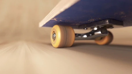 Close-up low-angle shot of a blue skateboard wheel and chrome truck in motion on a wooden surface