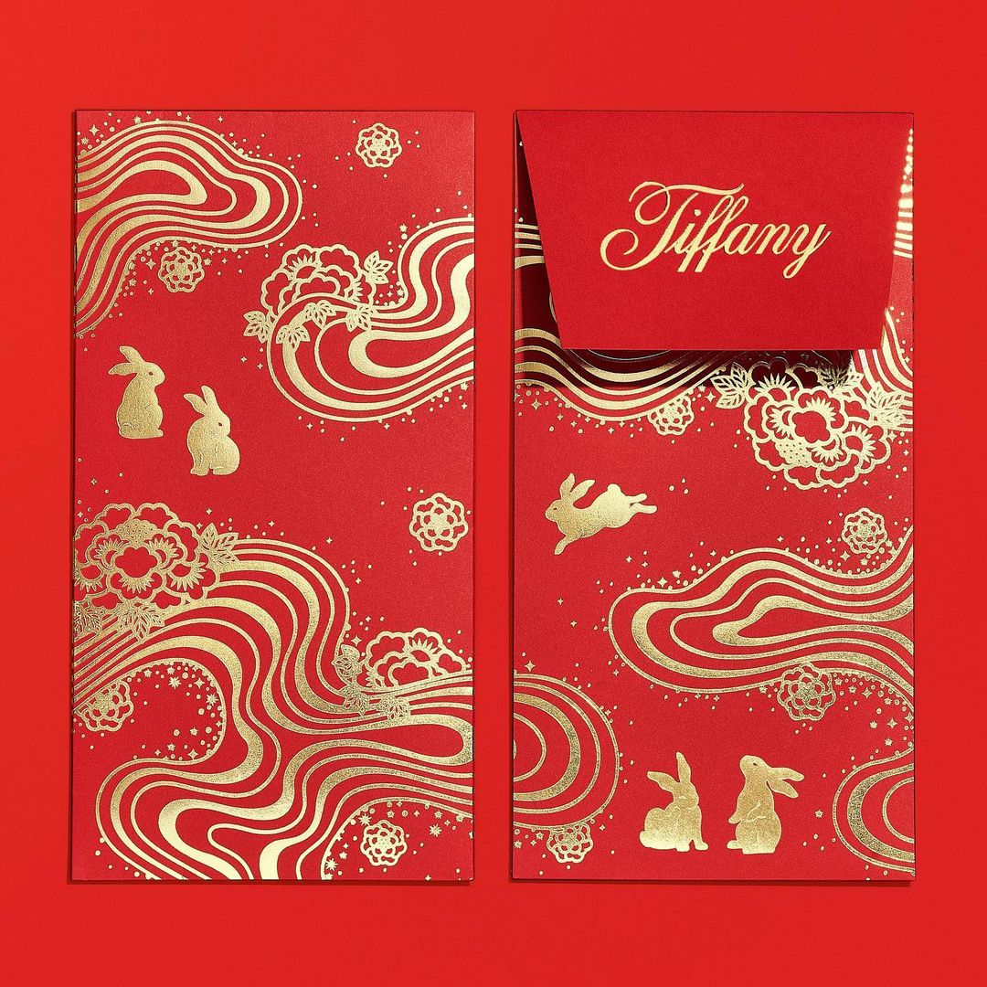 Two red Lunar New Year envelopes with gold decorations and the name 'Tiffany' in gold script on one, against a red background.