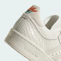 Close-up shot of an off-white sneaker heel with embossed snakeskin texture, suede collar, and colourful embroidered eye logo
