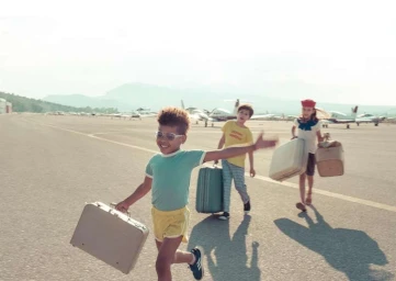 Three children running across an airfield with suitcases, photographed by Feli and Pepita in Frankfurt.