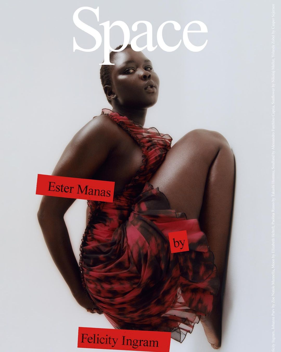 Editorial fashion shot featuring an African-descent female model in a red tie-dye dress, set against a bright, clean background.