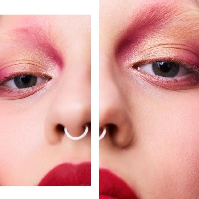 Extreme close-up of a model's face with creative makeup. Eyes are visible, with red lipstick and a nose ring. Beauty, fashion and editorial.