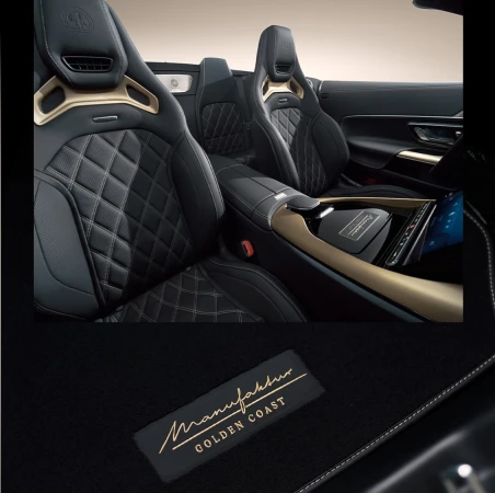 Luxury car interior featuring black leather seats with diamond stitching and golden trim, showcasing high-end automotive design.
