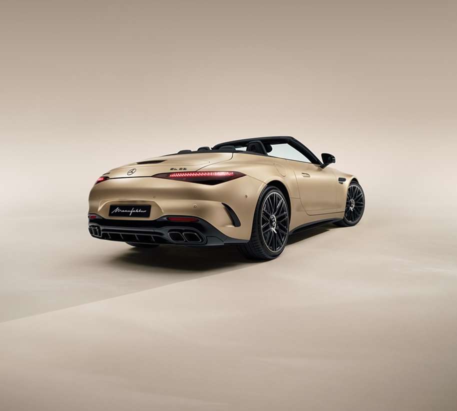 Rear view of a gold metallic Mercedes-Benz AMG SL roadster convertible parked in a photo studio, showcasing its elegant design.
