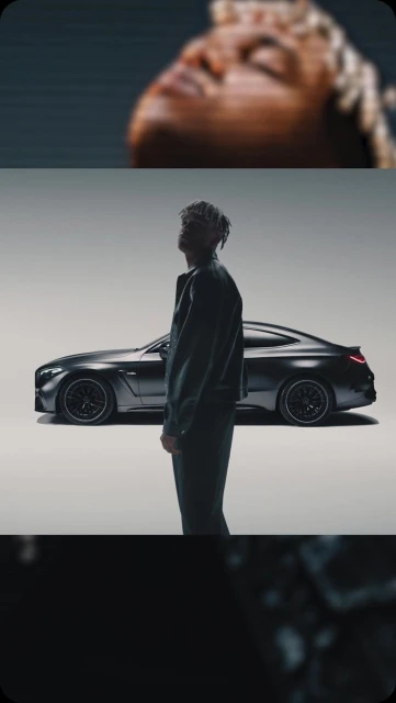 Adult male in black jacket poses next to a black coupe in a photo studio with seamless white background and moody, cinematic lighting.
