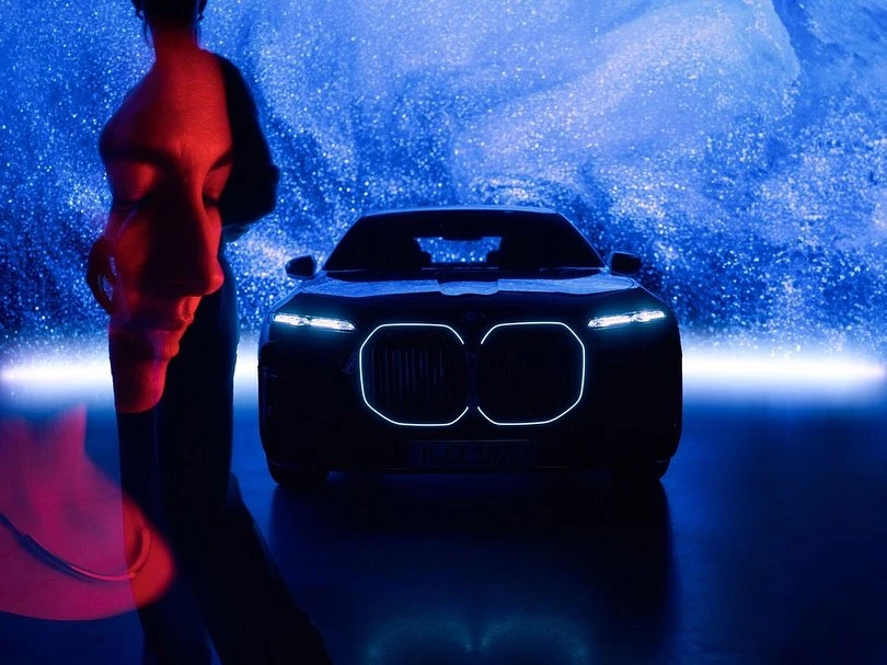 Automotive photoshoot features a sleek BMW car with neon accents alongside a blurred human form and dynamic blue abstract backdrop.
