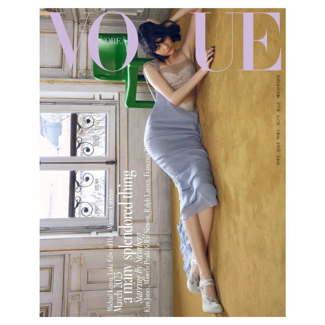 Vogue Korea magazine cover featuring a model in a blue dress posing against a golden wall with a window and chair visible.