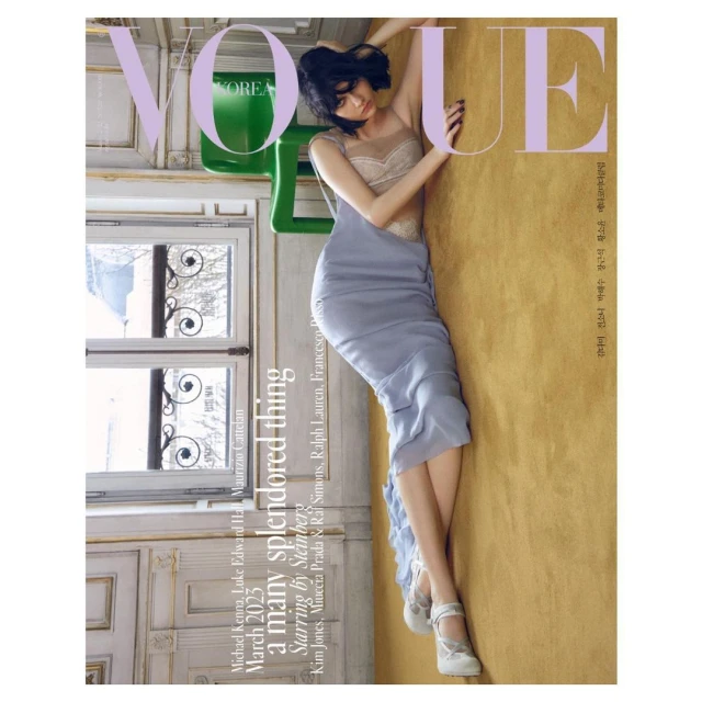 Vogue Korea magazine cover featuring a model in a blue dress posing against a golden wall with a window and chair visible.
