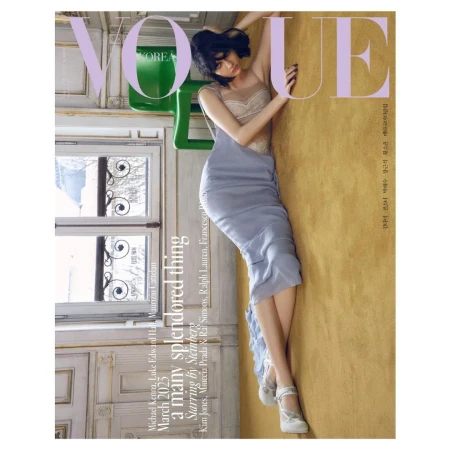Vogue Korea magazine cover featuring a model in a blue dress posing against a golden wall with a window and chair visible.