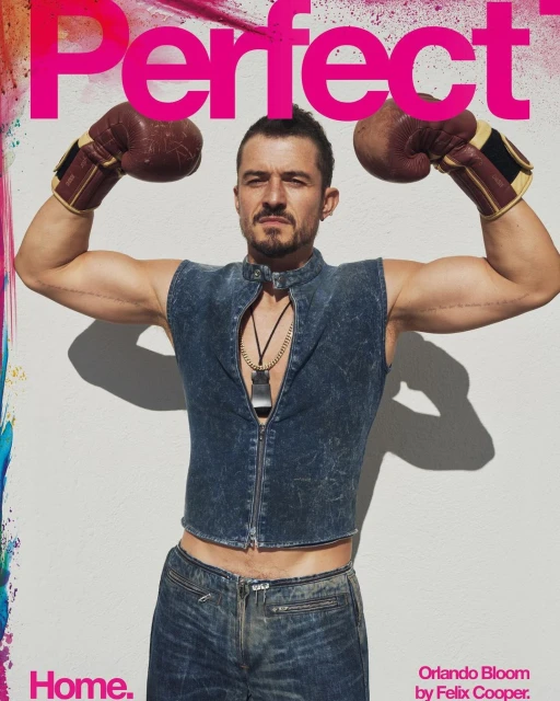 Orlando Bloom poses on the cover of Perfect magazine, wearing boxing gloves and a denim outfit against a white background with bright accents.