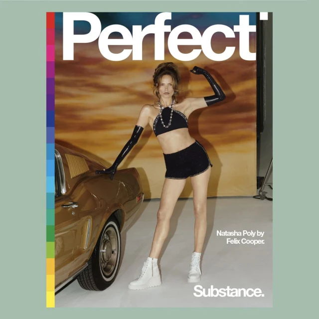 Fashion editorial featuring a woman in a black halter top, shorts, and white boots posing next to a vintage gold car against a backdrop.