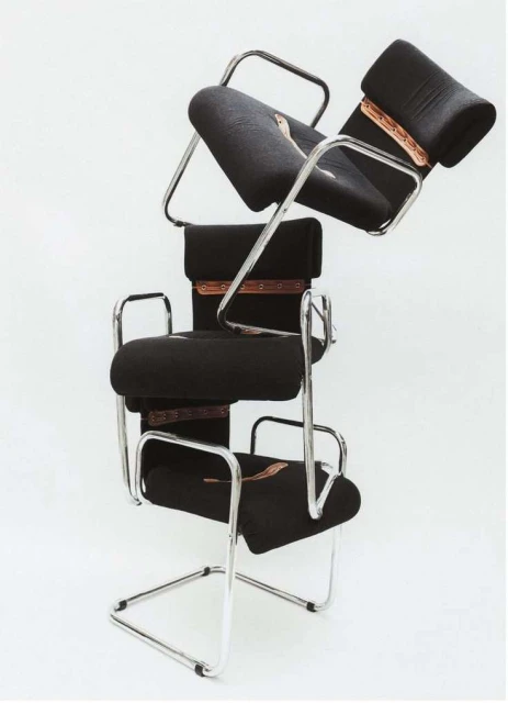 Conceptual product shot of three black Cesca chairs stacked on top of each other, set against a stark white background in a photo studio.