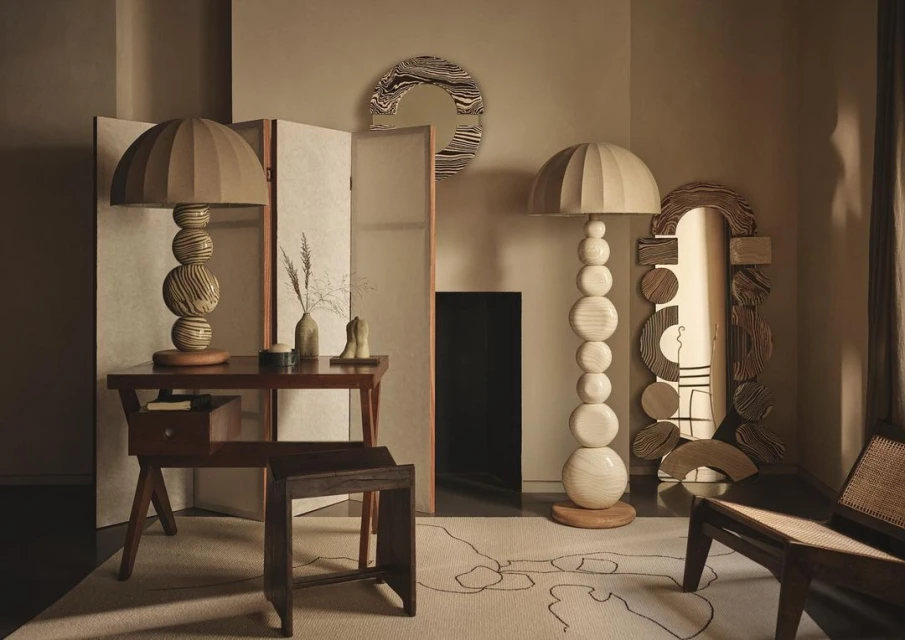 Living room interior featuring modern furniture: table, floor lamp, chair, folding screen, and mirror, with neutral color palette.