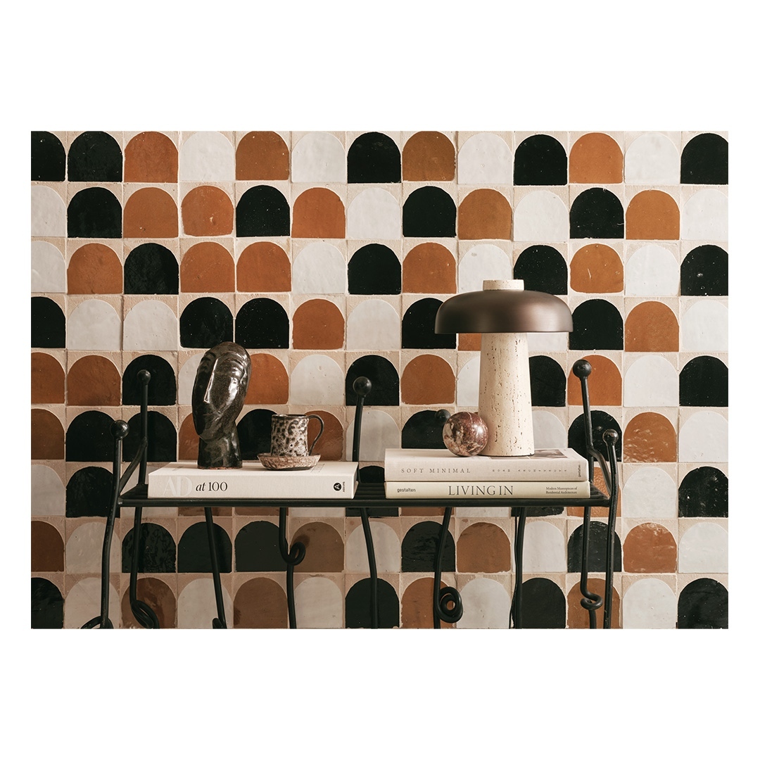 Still life featuring a mushroom lamp, books, an owl figurine, and a patterned tile backdrop. The composition evokes a cozy, artistic ambiance.