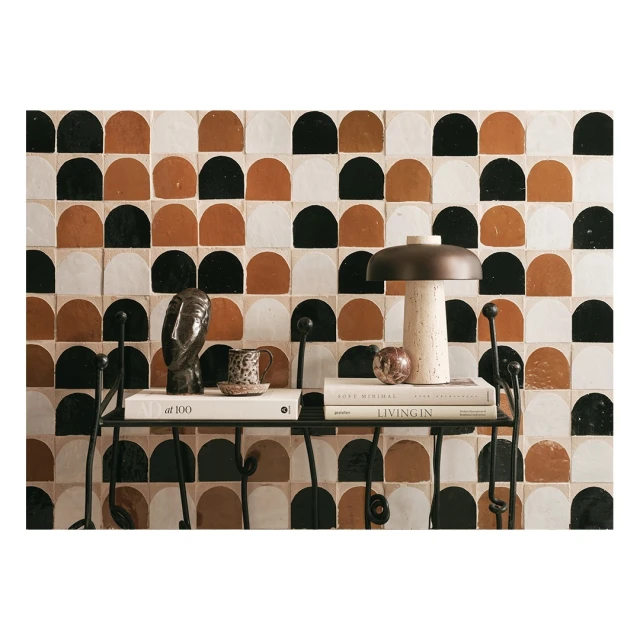 Still life featuring a mushroom lamp, books, an owl figurine, and a patterned tile backdrop. The composition evokes a cozy, artistic ambiance.