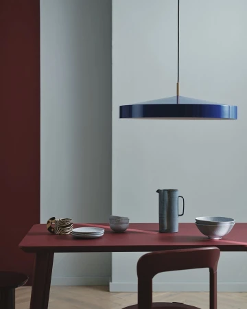 Interior design featuring a modern dining room setting with a pendant light, table, chair, and tableware in a minimalist aesthetic.