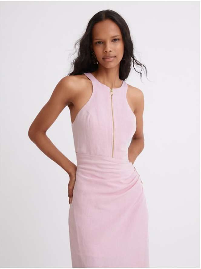 Model in pink halterneck midi dress with a front zipper posing against a plain neutral background