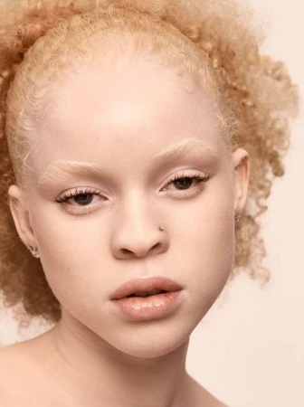 Close-up portrait of a woman with blonde curly hair and light features against a neutral background by Felix Wong