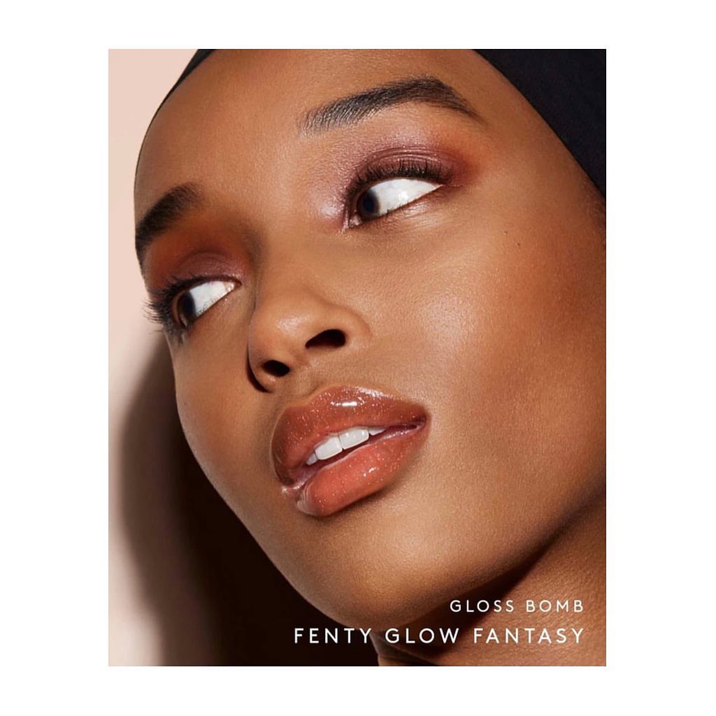 Close-up shot of a young adult woman with brown skin, wearing eye shadow and glossy lip stick for a beauty advertisement campaign.