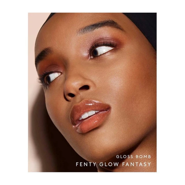 Close-up shot of a young adult woman with brown skin, wearing eye shadow and glossy lip stick for a beauty advertisement campaign.