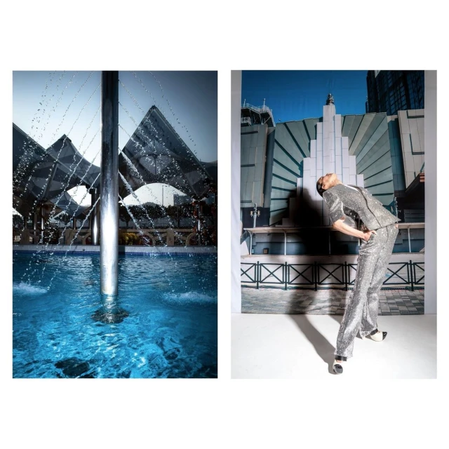 Fashion shot with a model wearing a silver suit in front of a building backdrop and an outdoor water feature in the background.