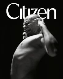 Black and white portrait of a shirtless bald man shouting with raised arms, captured by Fenn O'meally in Paris.