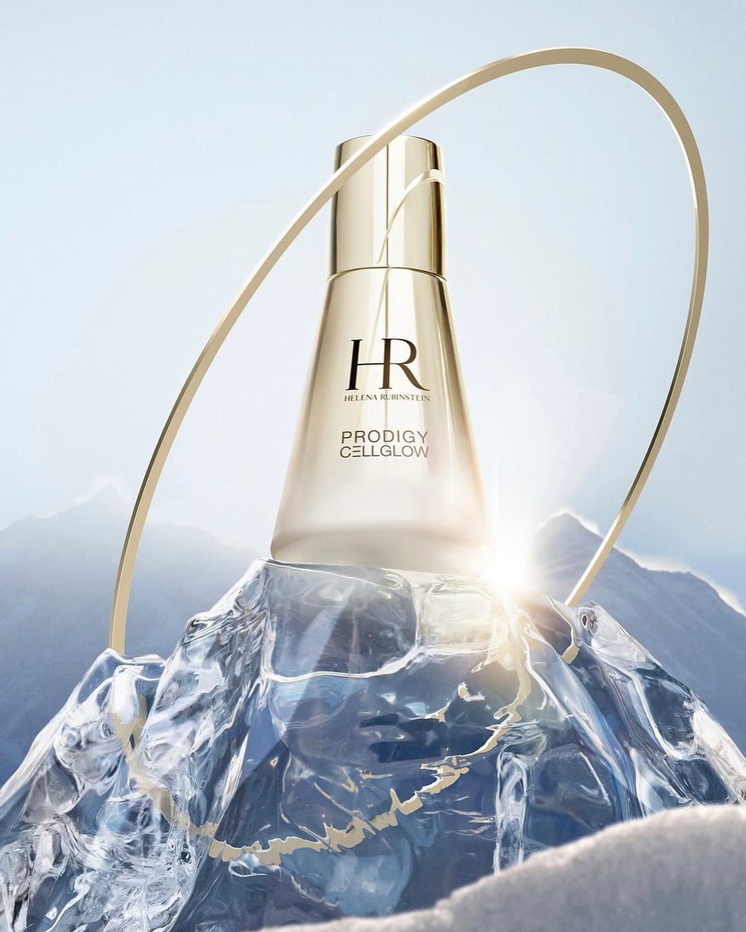Elegant gold skincare product from Helen Rubinstein, set on a chunk of ice with snowy mountains in the background, and gold arch.