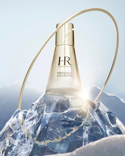 Elegant gold skincare product from Helen Rubinstein, set on a chunk of ice with snowy mountains in the background, and gold arch.