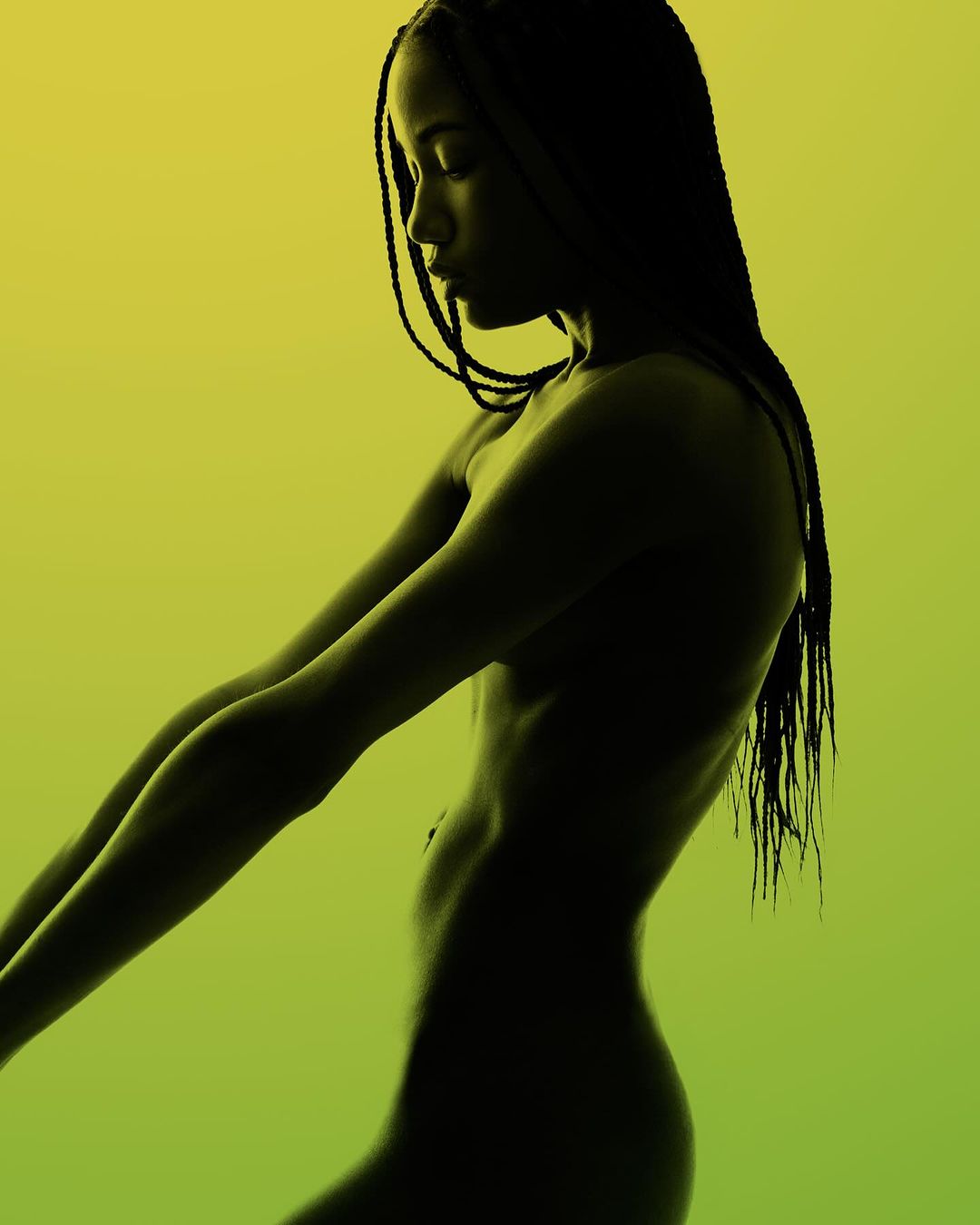 Silhouette of a slender, dark-skinned woman with long braided hair, posed with arms extended against a yellow-to-green gradient background.