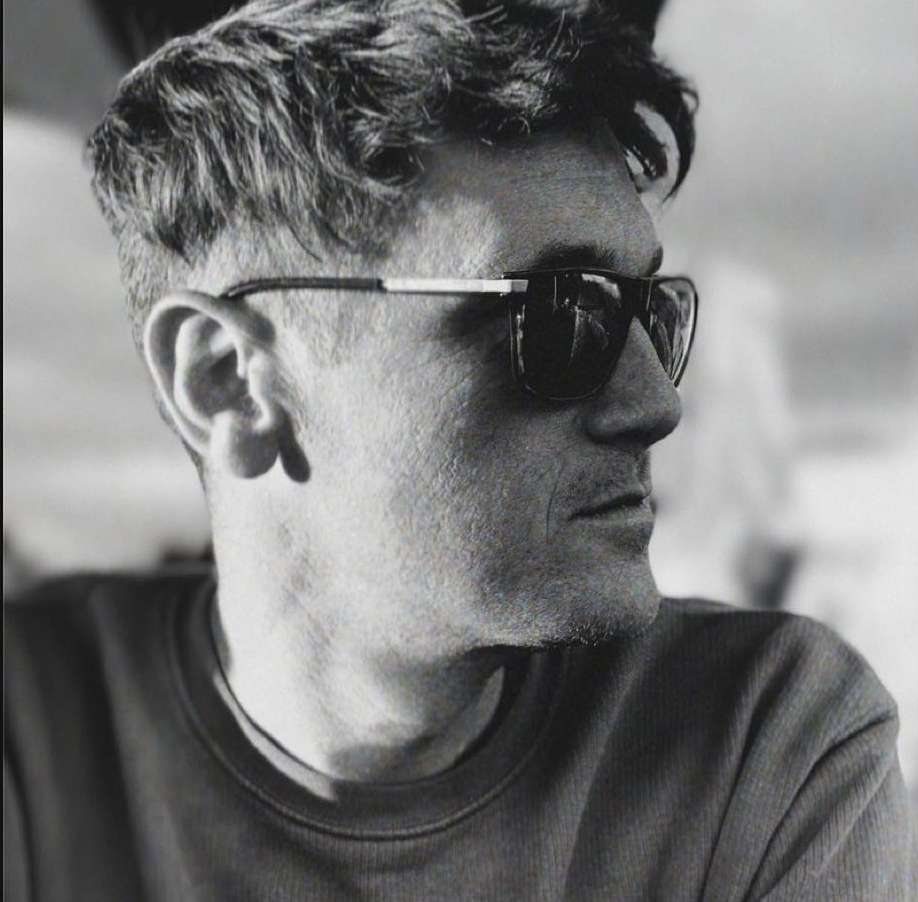 Black and white portrait of a man in dark sunglasses and a dark t shirt looking to the side in New York