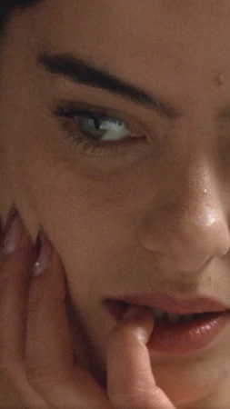 Close-up portrait of a woman biting her finger with manicured fingernails by Florent Augizeau
